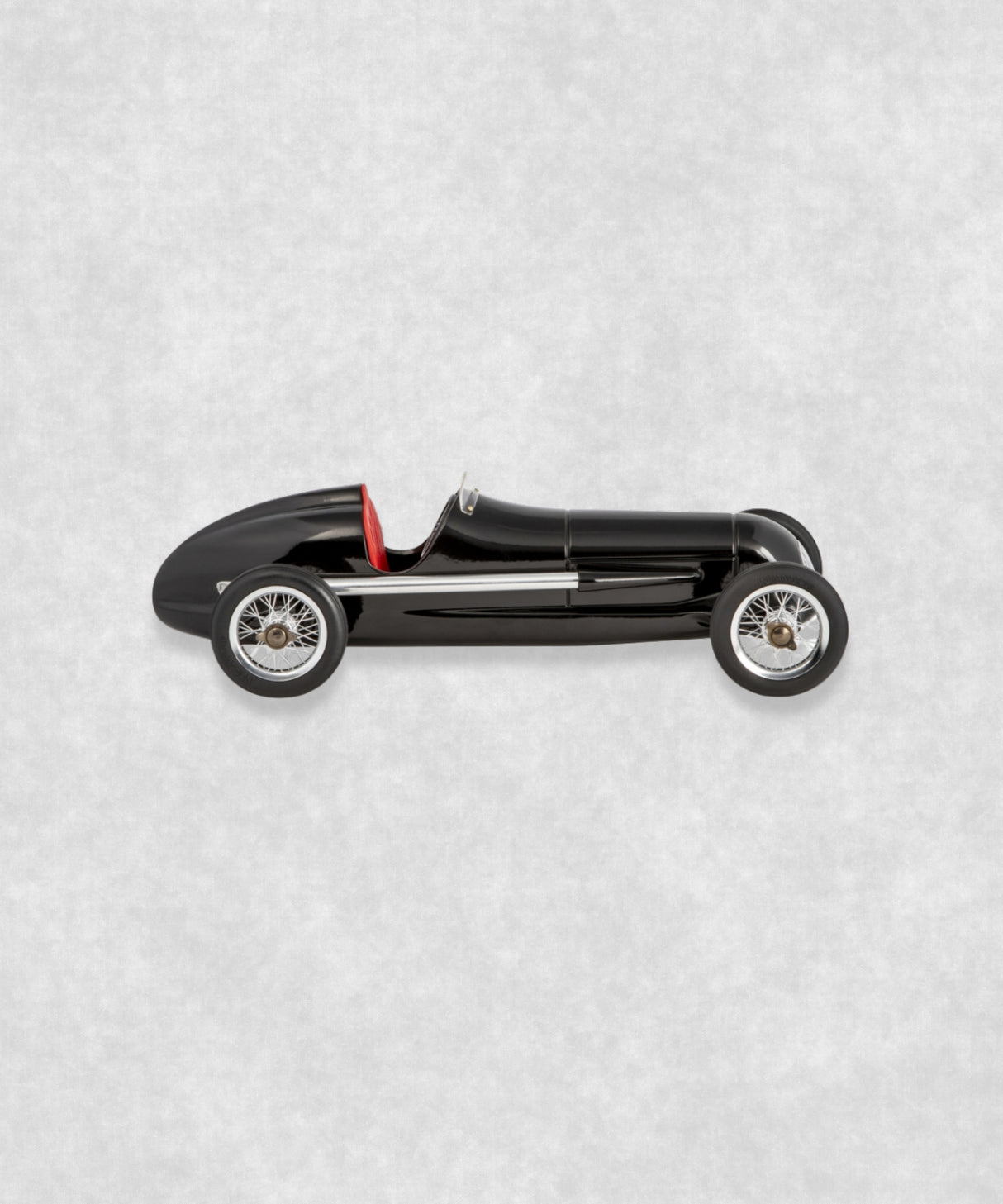 Vintage racing silberfeil car model inspired by classic Grand Prix racers and Silver Arrow legends, featuring a sleek black race car body with a striking red seat. A collectible car model for motorsport and classic car enthusiasts. Viewed from the left side.