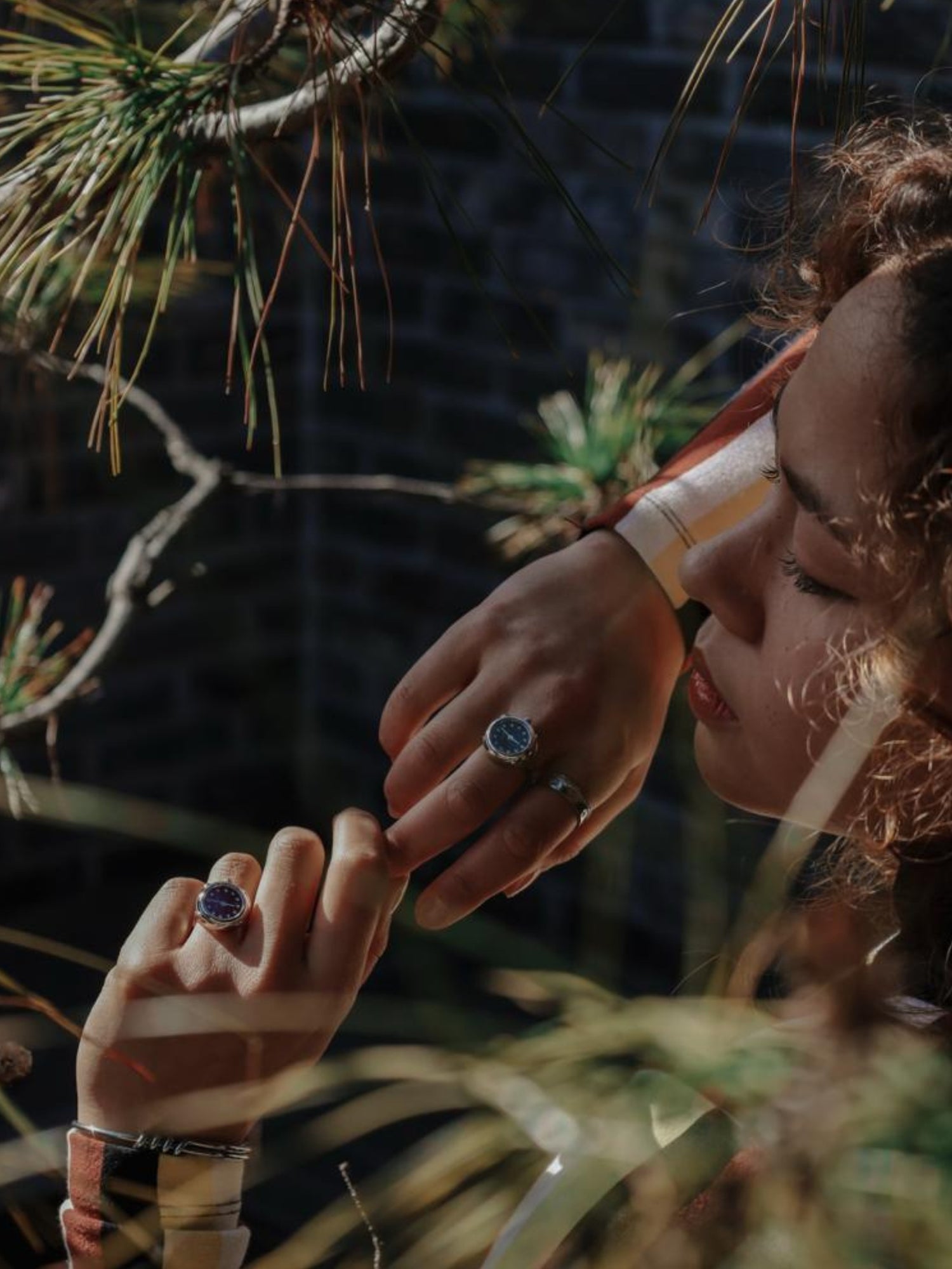 Ring watch elegant by Maison Davis in silver and blue worn on the hand of a woman in a garden