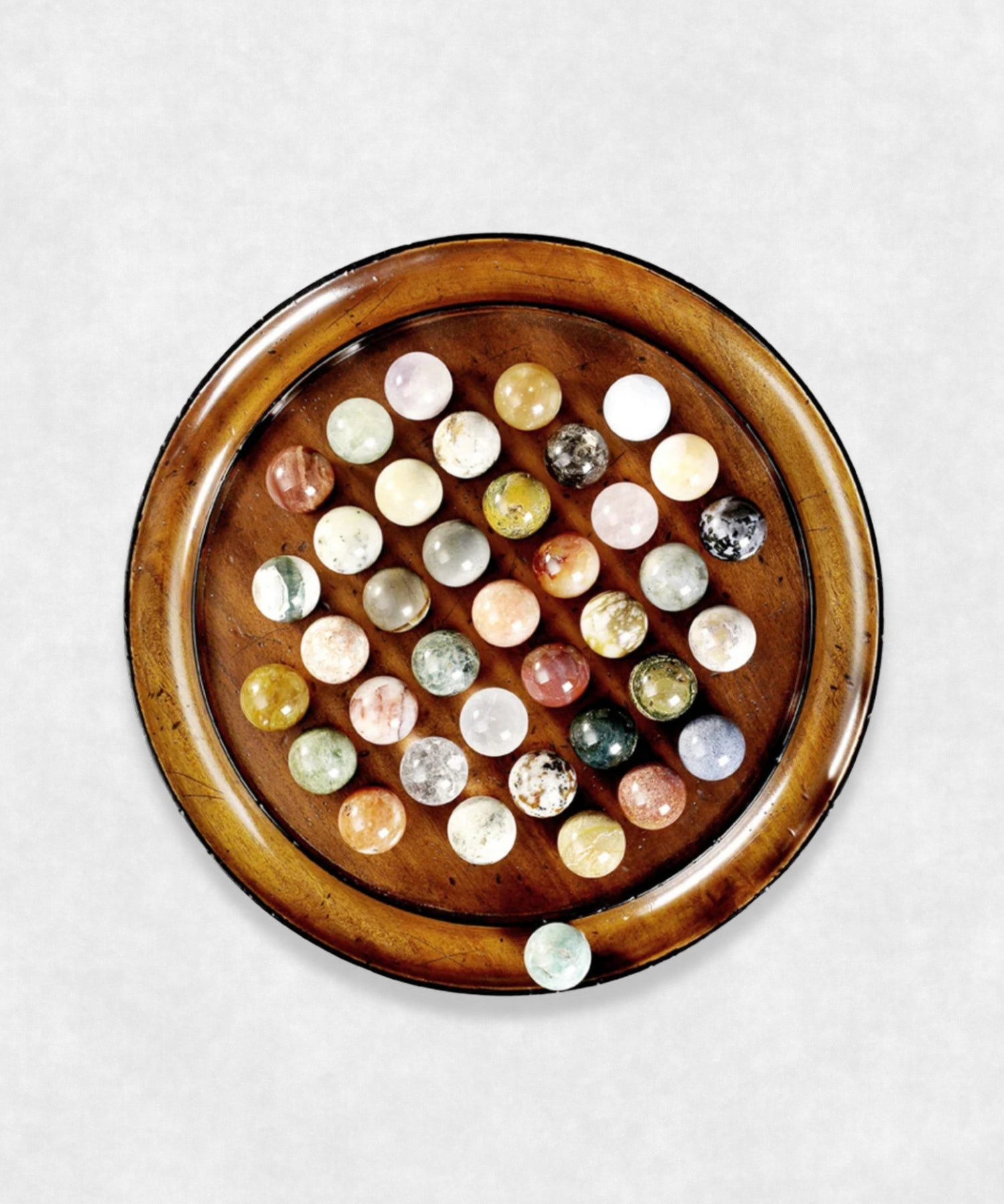 Top-down view of solitaire game board with complete set of gemstone playing pieces